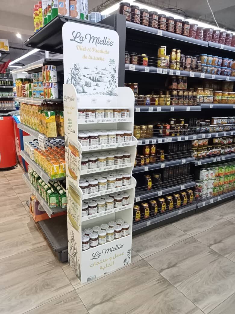 Présentoir La Miellée « Miel et produits de la ruche » garni de pots, en tête de rayon d'un supermarché